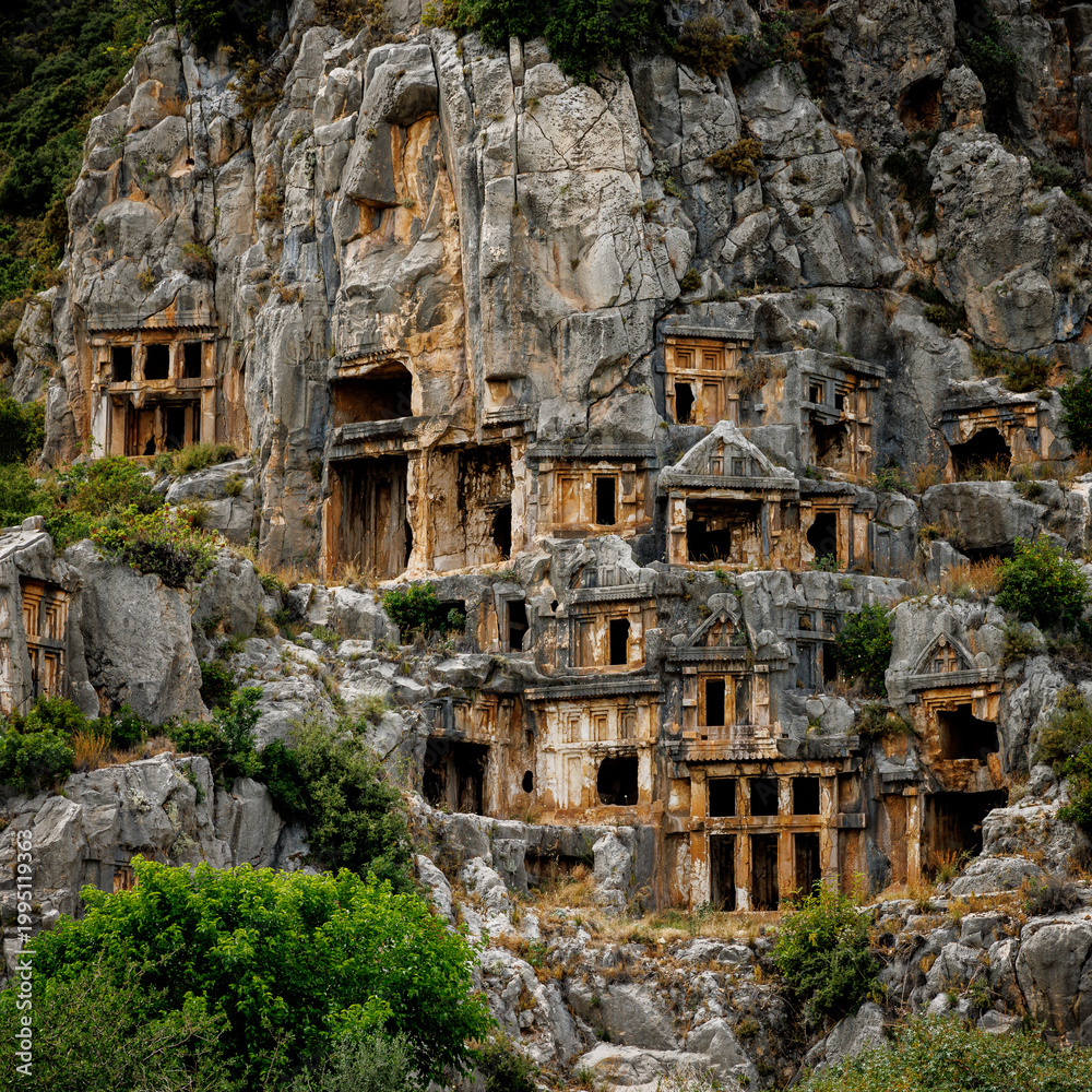 Fototapeta premium Ancient Lycian rock tombs carved into a mountain cliff side