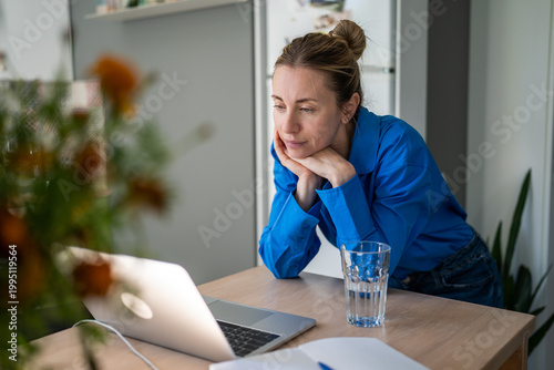 Картината върху платно Thoughtful mature woman engaged in learning process online on laptop at home, female watching professional speakers live streams and podcasts, lady changing career direction, getting new knowledge