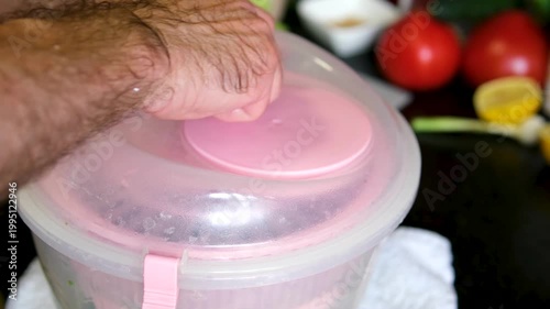 Dry spinach greens in a dryer Drying washed green spinach in plastic handheld home kitchen centrifuge type dryer. Cooking dinner from wholesome fresh organic ripe vitamin filled vegetable. 