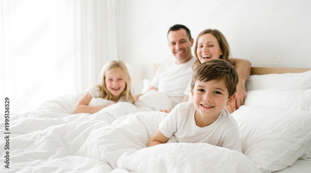 Fototapeta premium happy family mother, father and children laughing, playing and tickles in bed at home.