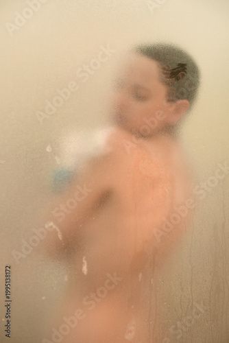 Young woman in a shower behind glass