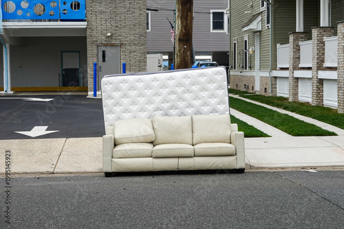 Old mattress and couch on the curb waiting for trash pickup