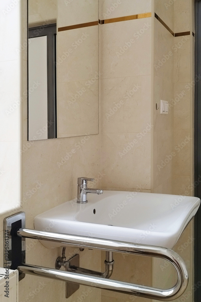 Fototapeta premium A sink is installed in a restroom with grab bars for support by users in need