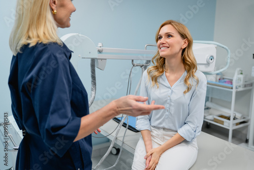 Foto Female doctor talking with patient in X-ray room, professional medical consultat