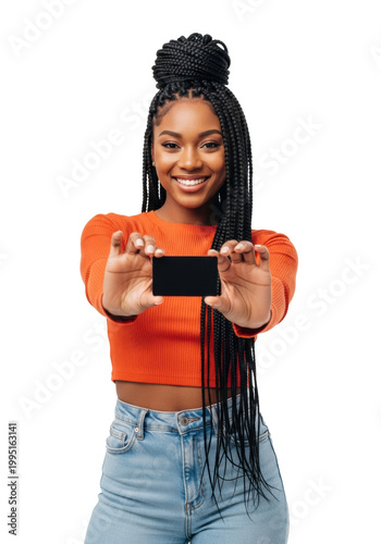 A vibrant young black woman with box braids and a cheerful smile holds a blank black gift card in an orange crop top against a bright white studio background, retail advertising concept