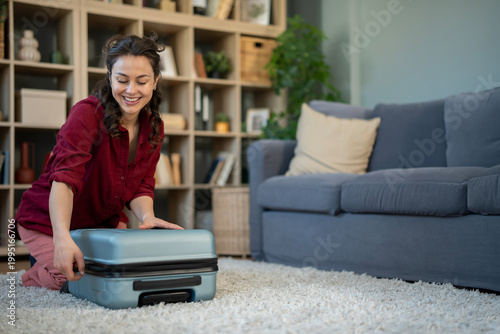 Fotografie Happy woman packing suitcase for travel vacation trip