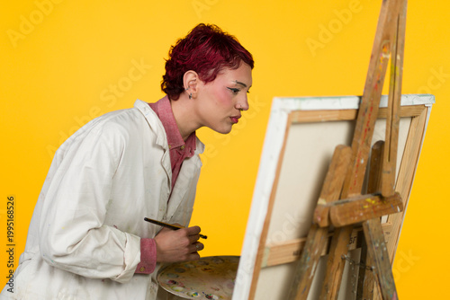 Fényképezés Artist concentrating on painting canvas using brush