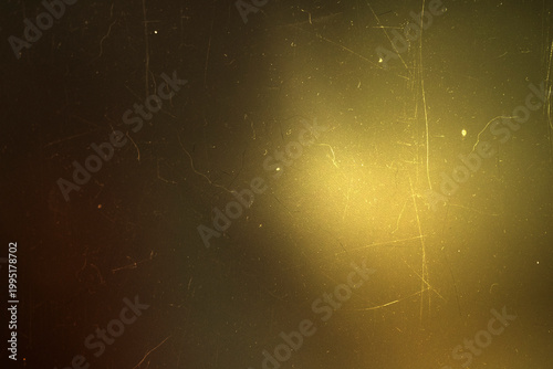 Golden warm light leak on a scratched dark vintage film texture background