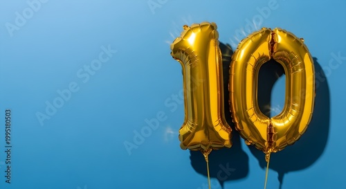 Gold Foil Balloons Number 10 for 10th Birthday or Anniversary Celebration, Shiny Metallic Tenth Year Milestone Symbol on Blue Background with Copy Space
