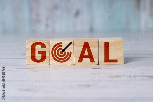 Wooden blocks or cubes that spell the word goal, the 'o' is a target or goalpost.
