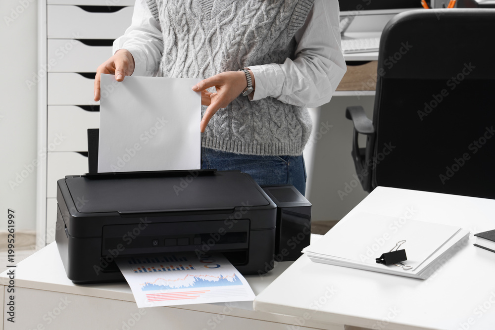 Fototapeta premium Businesswoman using modern printer in office