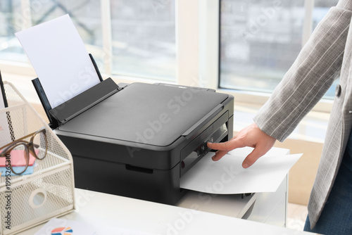 Obraz na płótnie Businesswoman using modern printer in office