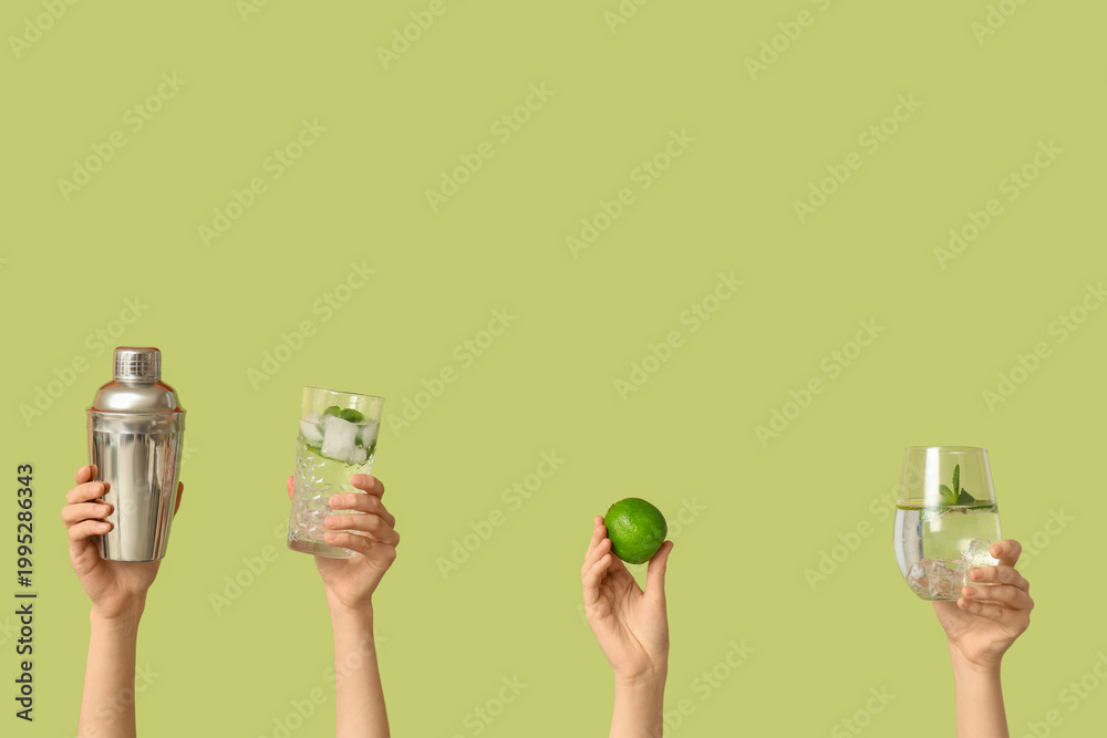 Fototapeta premium Female hands with glasses of mojito and shaker on green background