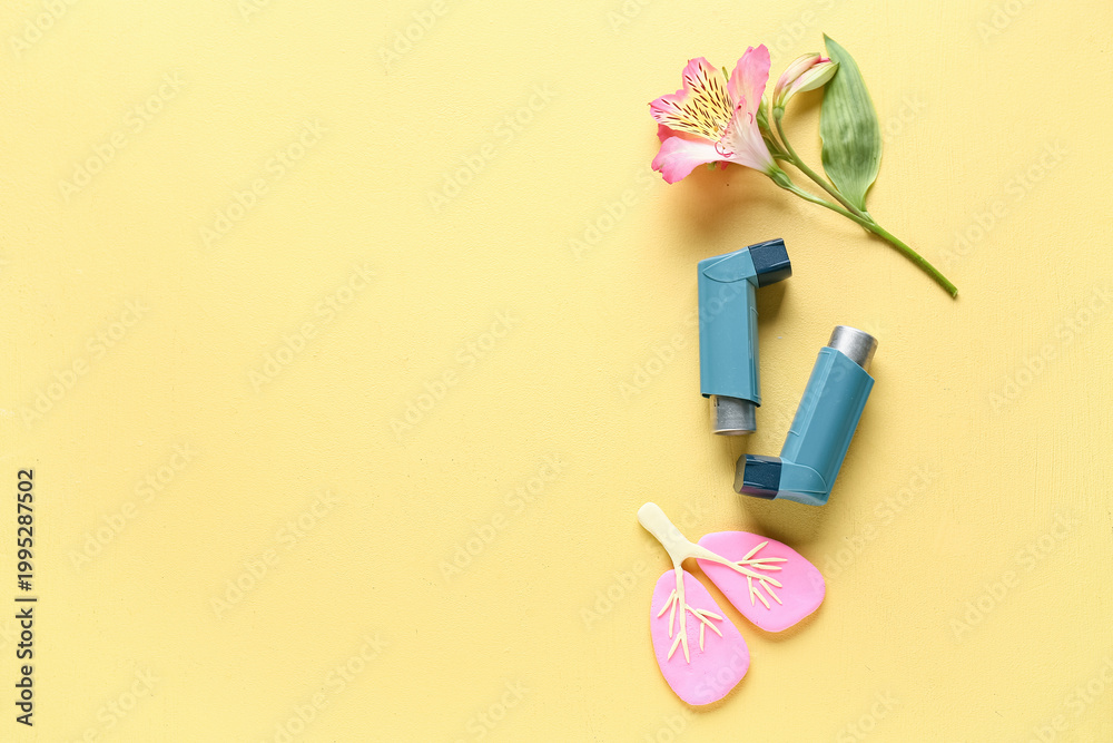 Fototapeta premium Asthma inhalers with lungs figurine and alstroemeria flower on yellow grunge background