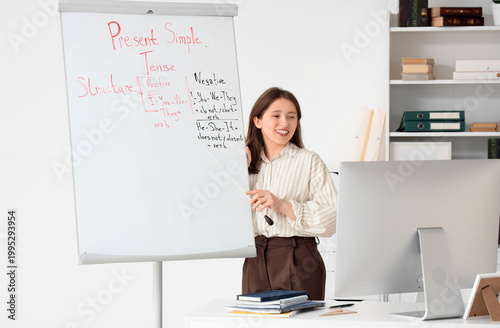 Female tutor giving online English lesson near flipchart at home