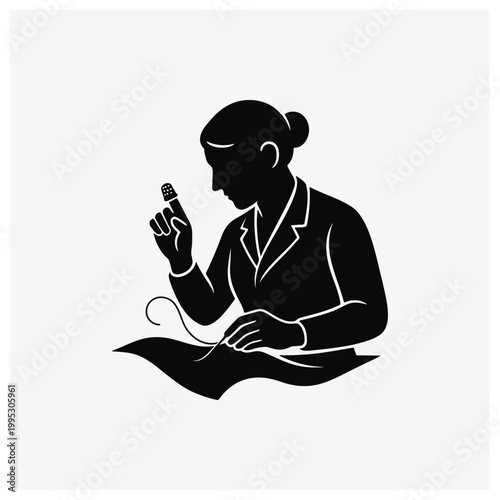 Silhouette of a seamstress or tailor sewing fabric at a table