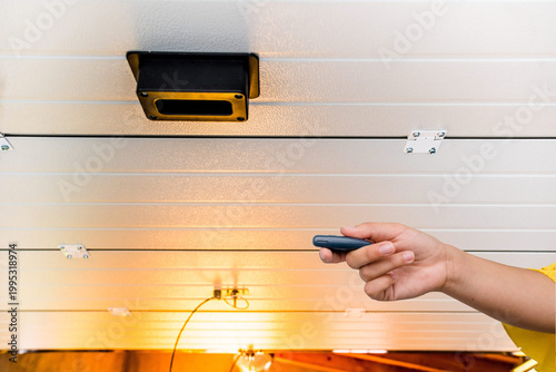 Garage door PVC. Hand use remote controller for closing and opening garage door
