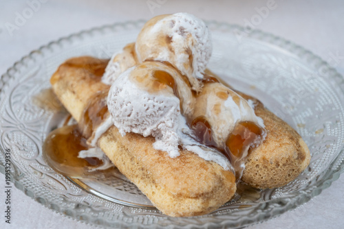Deconstructed Tiramisu with sweet ladyfinger biscuits layered with creamy ice cream and generous caramel drizzle, presented in an elegant glass dish, in Theth, Albania.