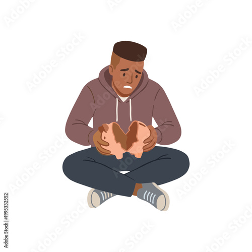 A man sits cross-legged showing sadness with a broken heart.