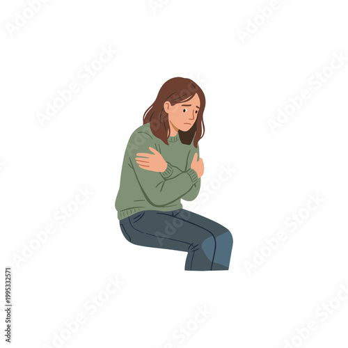 A woman sits alone showing sadness and fear with her arms wrapped around herself.