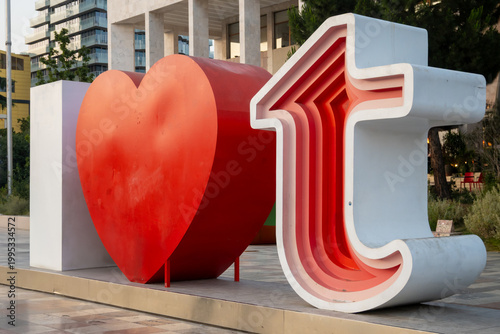 An intimate view of the popular I LoveT installation, showcasing the bold red heart and the unique layered design of the 'T', illuminated by warm sunset light.