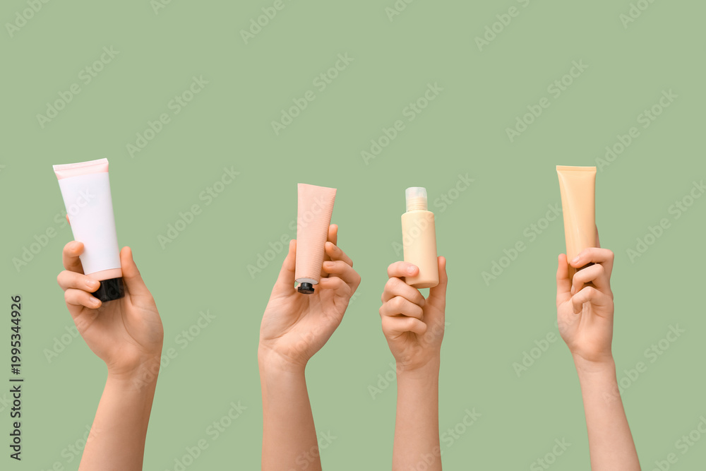 Fototapeta premium Female hands with different cosmetic products on green background