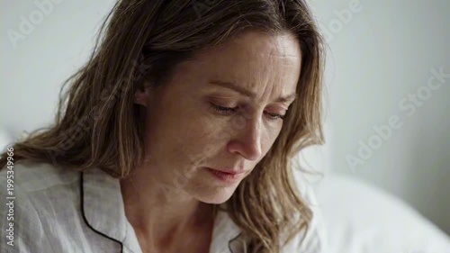 Morning bed portrait of a sleepless woman with a disappointing face, intimate close scene with white bedding conveying anxiety, fatigue, emotional overwhelm, regret, burden, and private distress