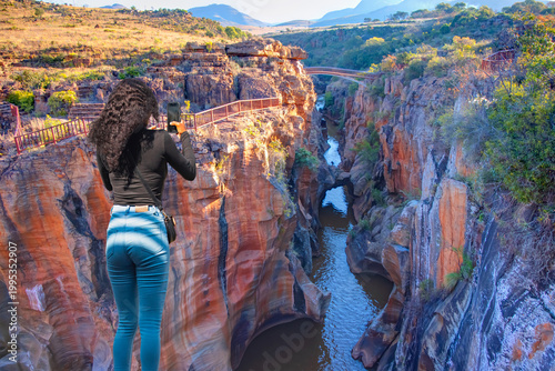 Foto A beautiful young South African girl with braided hair watches the canyon - Blyd
