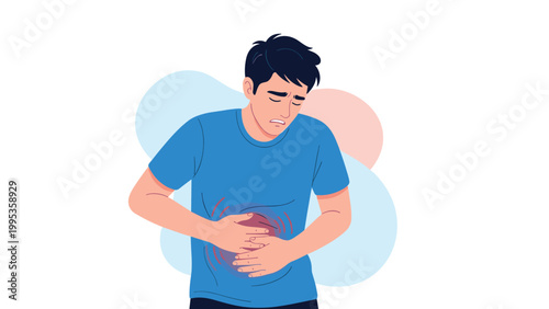 Young man in a blue t-shirt holding his stomach and showing a painful expression due to an abdominal ache at home.