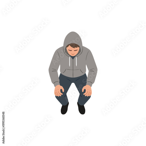 A man wearing a gray hoodie sits on the floor indoors.