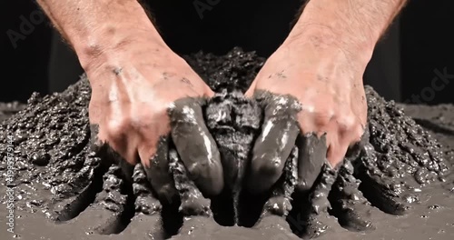 Hands manipulating wet concrete in a creative process, showcasing texture and technique