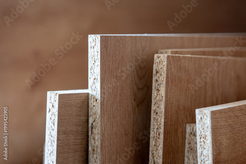 Fotografi Stack of chipboard panels in carpentry workshop, particle board sheets detail, w