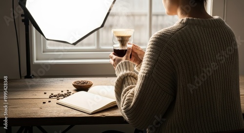 Person Enjoys Brewing Coffee While Reading at Cozy Table