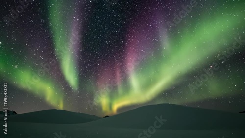 Stunning Aurora Borealis Dancing Across the Night Sky Over Snowy Landscape.