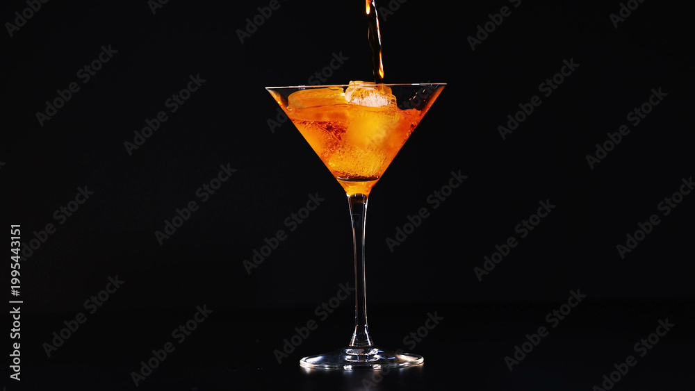 Fototapeta premium Orange Aperitif Being Poured into a Cocktail Glass with Ice