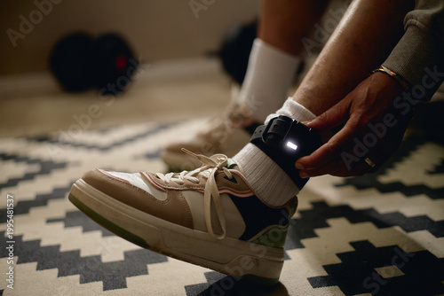 Foto Close up of woman fastening electronic ankle monitor at home, representing house arrest, legal surveillance, restricted freedom