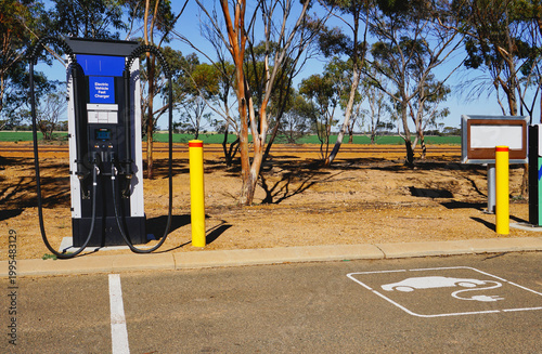 Rural electric vehicle charging station at a rest stop with EV parking sign and gum trees