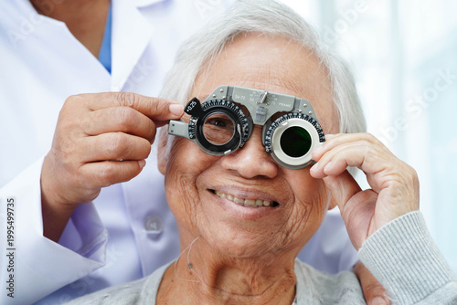 Optometrist checking Asian elderly woman ophthalmic vision eye test and using optical trial frame.