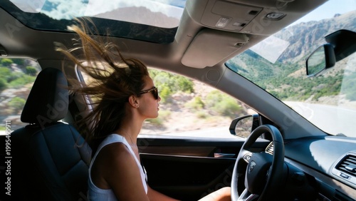 Woman driving with hair blowing through open sunroof