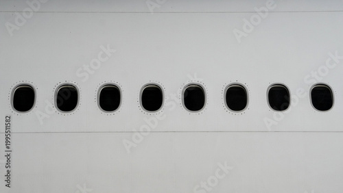 Bilde på lerret Minimalist view of five airplane windows in a row on white fuselage exterior of