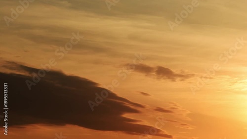 Vibrant sunset sky timelapse transitioning from glowing golden sun to dramatic orange clouds and blue dusk