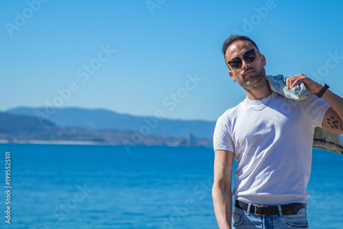 casual man looks at camera with jacket on shoulder