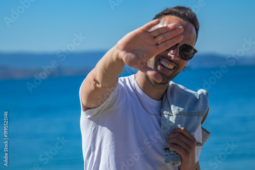 casual man looks at camera with jacket on shoulder