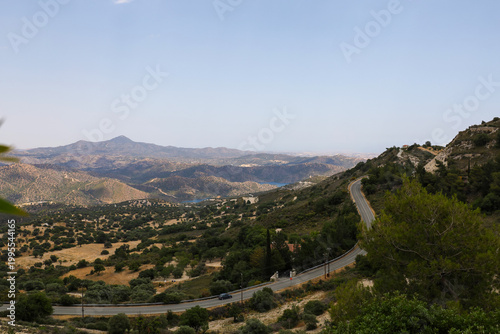 Scenic landscape of Pano Lefkara village area, Cyprus, with a winding mountain road and Mediterranean hills under a clear blue sky