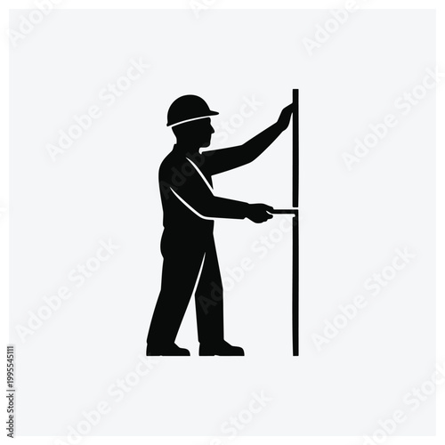 Silhouette of a worker raising or fixing a pole or sign.
