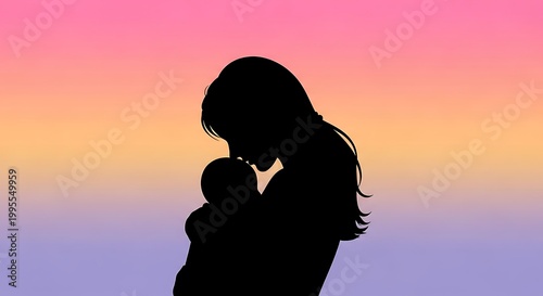 Silhouette of a woman holding and kissing her baby at sunset