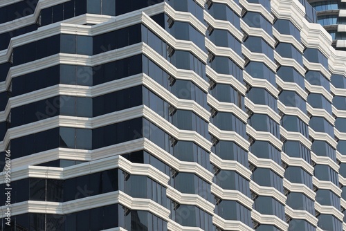 Valokuva Modern skyscraper facade with repeating geometric patterns and dark glass window