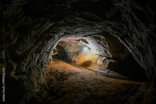 Canvas Print Dark tunnel with an underground spring in the Sablinsky Caves, Leningrad region