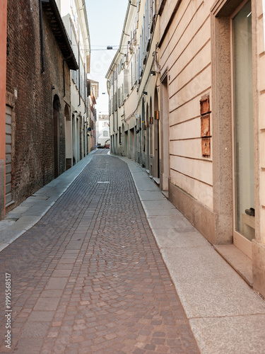 Narrow cobblestone street between historic buildings in Italian city