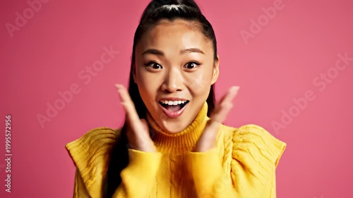 Young Asian Woman Expressing Surprise and Excitement with Wide Eyes and Open Mouth.